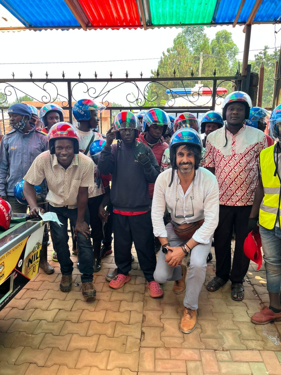Worldproject team with local community members in Uganda wearing safety helmets